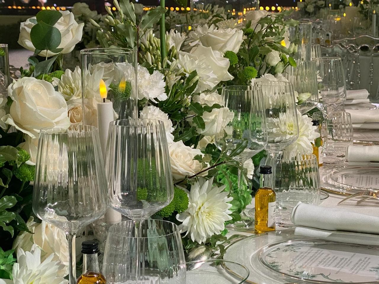 Roses blanches, verres en cristal et menu sur une table de mariage élégante