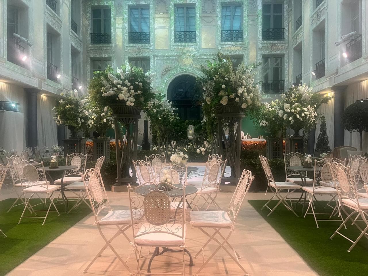 Cour d’un hôtel particulier parisien transformée en jardin de réception avec tables et chaises fines